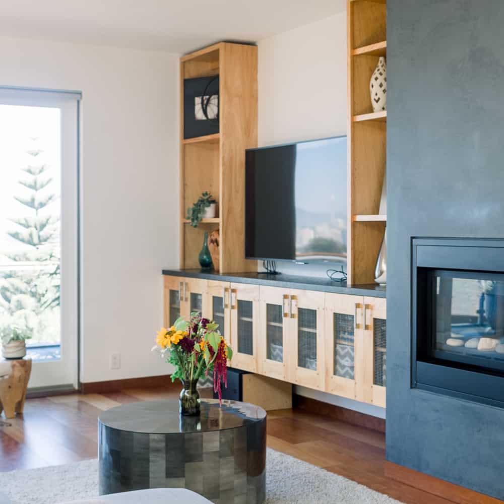 A cozy living room with a fireplace and a TV, perfect for relaxing and enjoying a warm ambiance. San Diego Home Remodeling