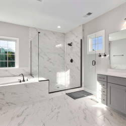 A spacious bathroom with elegant marble flooring and pristine white walls.