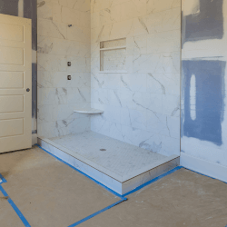 A bathroom that is being remodeled with blue tape.