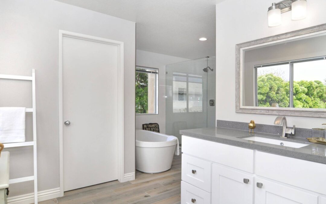 A bathroom with a white sink and gray counter top. - Bathroom Remodel Vs Renovation