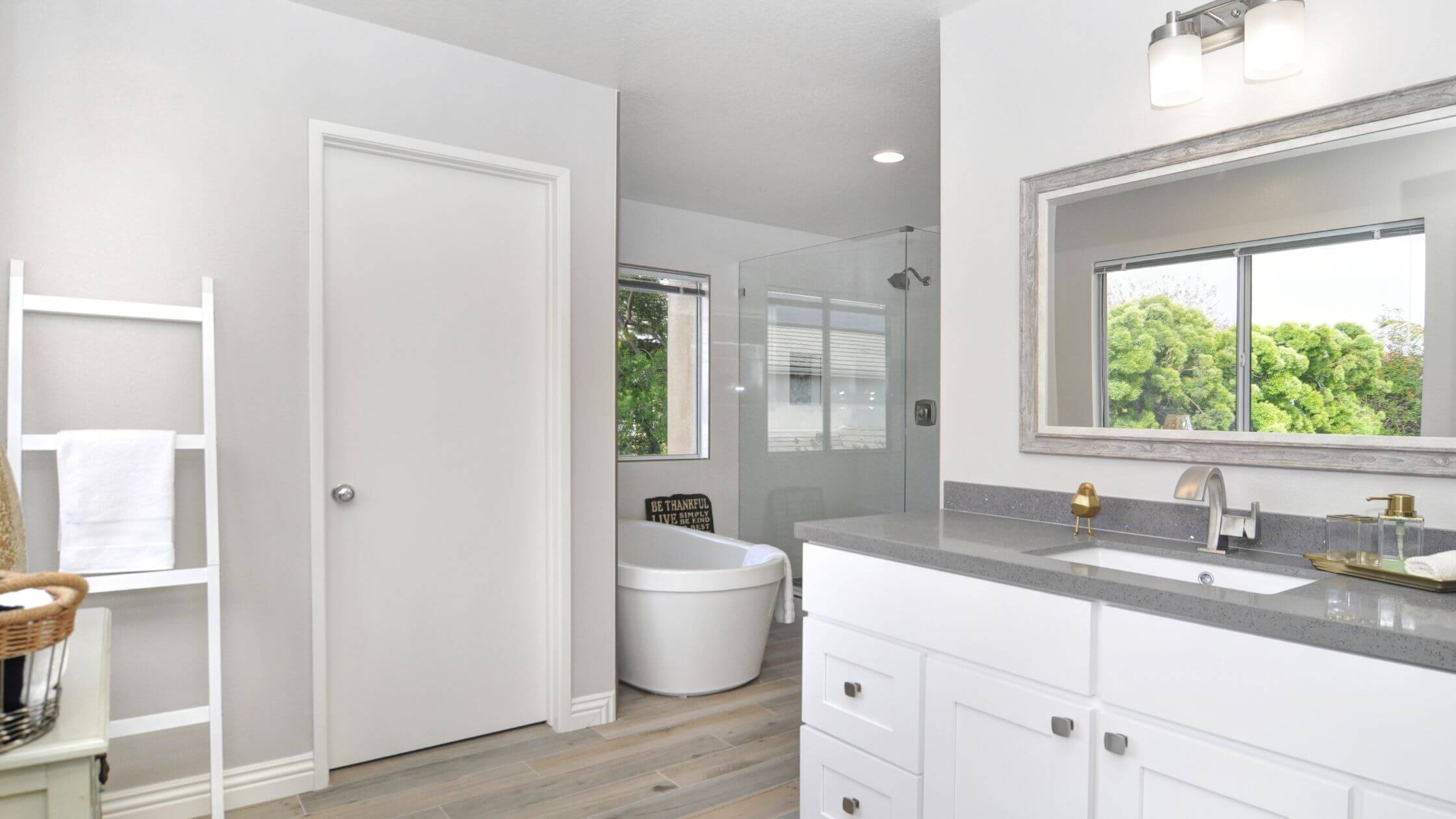A bathroom with a white sink and gray counter top. - Bathroom Remodel Vs Renovation