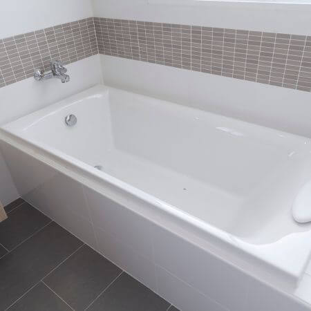 Bathroom-Conversion-5 A white bathtub in a clean, modern bathroom with light-colored walls and a bright atmosphere.