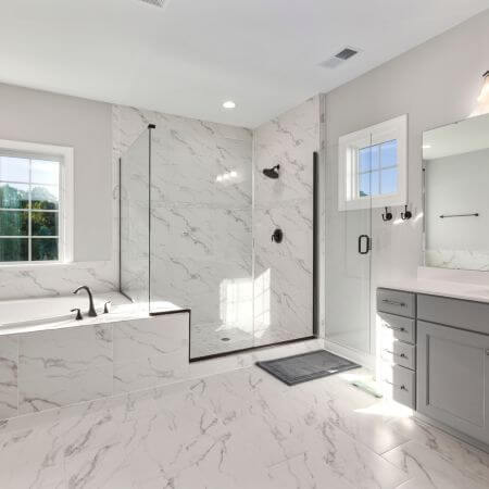 Bathroom-Remodeling-4 A modern bathroom with a white bathtub, sink, and toilet.