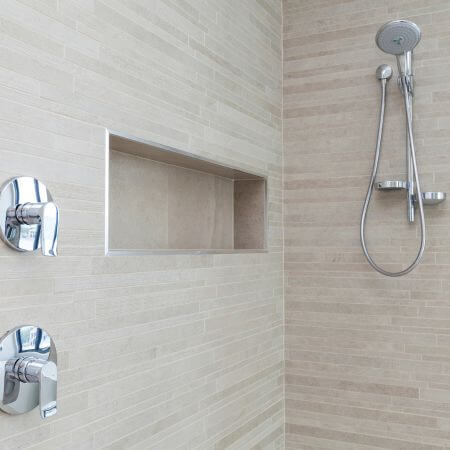 Shower-Remodeling-4 A modern shower head mounted on a tiled bathroom wall.